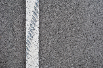 Fototapeta premium Asphalt texture with white line and tire marks . Top view