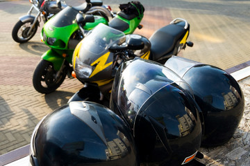 Safety helmets on the background of powerful motorcycles Kawasaki and Honda.