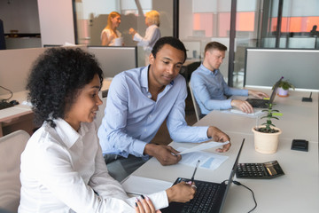 Black male supervisor analyze female trainee work at workplace