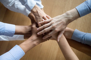 Top view of colleagues join hands motivated for shared success