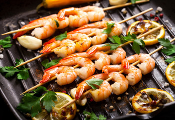 Closeup of prawns Shrimps roasted on pan with lemon, garlic and herbs.