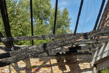 Burnt interior of the house after a fire. Charred black roof beams © Joachim Heller