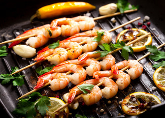 Closeup of prawns Shrimps roasted on pan with lemon, garlic and herbs.
