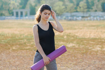 A young slim athletic girl in sportswear with snakeskin prints performs a set of exercises. Fitness...