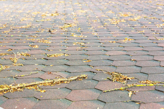 Yellow leaves lie on the roof of the building of brown, soft tiles.
