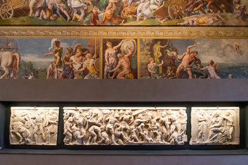Colorful medieval fresco and marble stone with engraved sculptures in exhibition in an itlaian museum