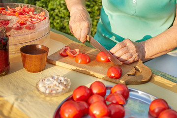 Female hands in the garden cutting tomatoes