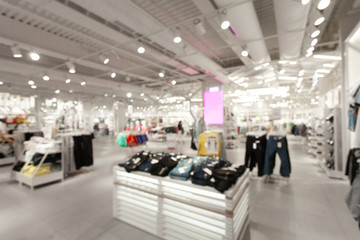 Sale and seasonal change of collection. Blurred View of fashionable clothing store in shopping center. Led lighting on the ceiling. Fire system and air conditioning system in retail shop. - 288250101