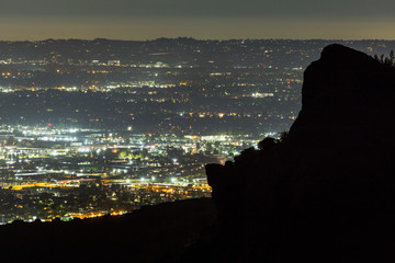 Predawn view across the San Fernando Valley with Santa Susana Mountains rock outcropping silhouette in Los Angeles, California.  