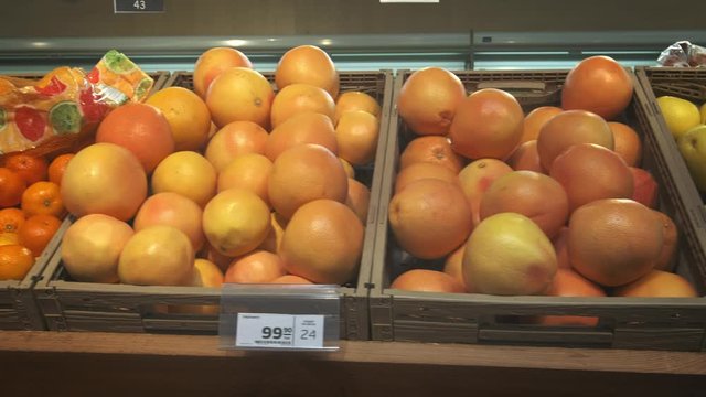 Lots of oranges and citrus fruits. A bunch of fruits lie in the supermarket, camera span