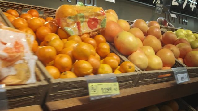 Lots of oranges and citrus fruits. A bunch of fruits lie in the supermarket, camera span