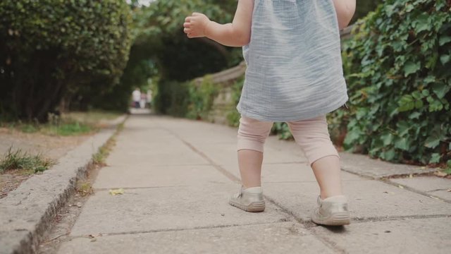 Small kid girl walking on the city street