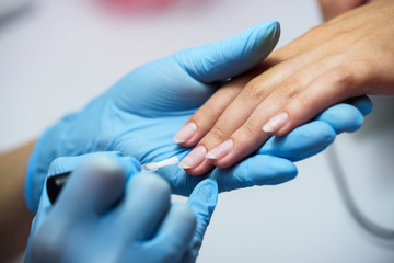 Manicure process in beauty salon, close up