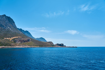 Fototapeta premium Rocky sea coast of Crete, Greece under a clear blue sky. Copy space.