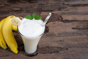 Banana fresh cocktail vanilla smoothies juice white fruit beverage healthy the taste yummy In glass for milkshake on wooden background from top view.