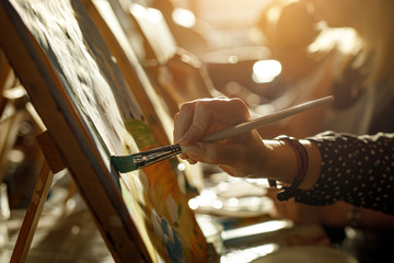 hand of artist with brush painting picture