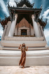 beautiful young boho woman in elegant dress at the ancient temple background
