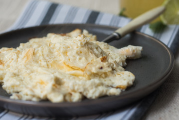 homemade egg and milk omelet on a dark ceramic plate on a towel. Homemade Breakfast Right