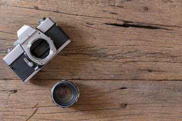 Top view of Old film camera and lens on wooden background and  copy space
