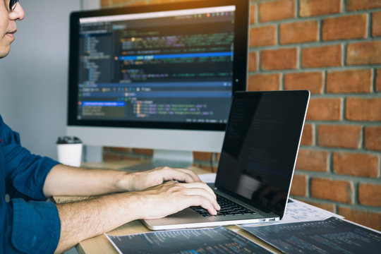 Asian man working code program developer computer web development working design software on desk in office.