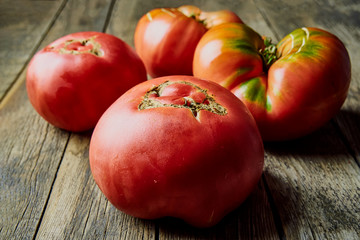 Colorful, fresh, large homegrown tomatoes on an old wooden table. Harvesting .