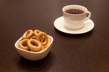 cup of black tea on a saucer with bagels