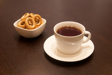 cup of black tea on a saucer with bagels