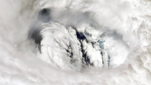 Distant Aerial View of Airplane Flying Over the Eye of a Massive Hurricane - Elements of this Video furnished by NASA 