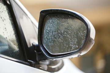 Wing Mirror of white car between raining.