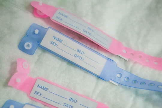 Close-up image with new born babies tags, blue for boys and pink for girls in a maternity
