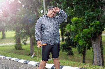 fat obese man doing exercises with jumping rope overweight guy training workout weight loss