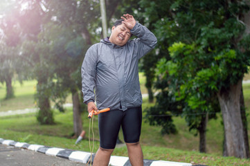 fat obese man doing exercises with jumping rope overweight guy training workout weight loss