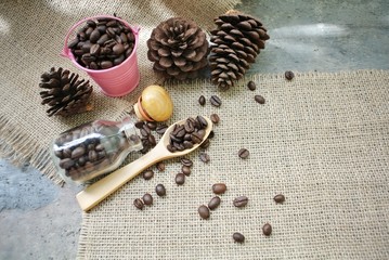 Roasted coffee beans in a pink zinc bucket on a sackcloth background.