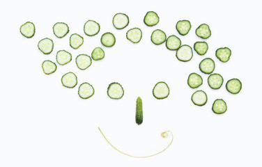 A woman's smiling face made of cucumbers on a white background