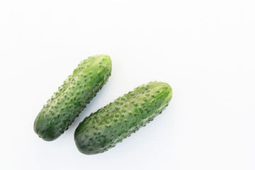 A pair of fresh cucumbers shot above on a white background