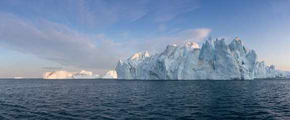 Icebergs in front of the fishing town Ilulissat in Greenland. Nature and landscapes of Greenland. Travel on the vessel among ices. Phenomenon of global warming. Ices of unusual forms and colors.  © Michal