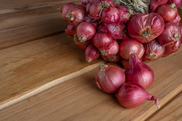 Shallots placed on brown wood.