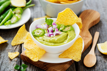 Bowl of fresh guacamole sauce  with corn chips nachos.