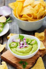 Bowl of fresh guacamole sauce  with corn chips nachos.