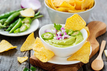 Bowl of fresh guacamole sauce  with corn chips nachos.