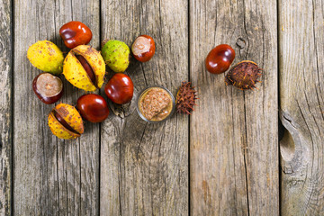 Obraz premium medicine and cosmetics raw ingredient: alcohol tincture from horse chestnuts on old wood table background