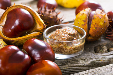 medicine and cosmetics raw ingredient: alcohol tincture from horse chestnuts on old wood table background