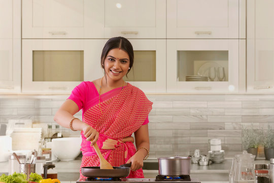 woman in saree cooking in the kitchen	