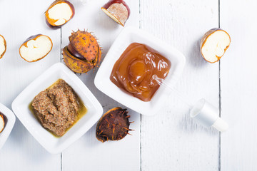 medicine cream, ground conkers tincture with alcohol and sliced seeds from horse chestnuts, on white wooden table