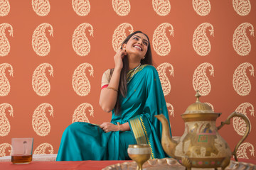 woman in saree having tea at home