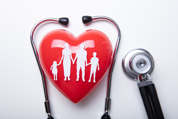 Family Cut Out Over Red Heart With Stethoscope