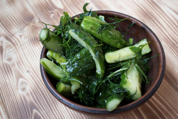 pickles with dill on a clay plate on a wooden table