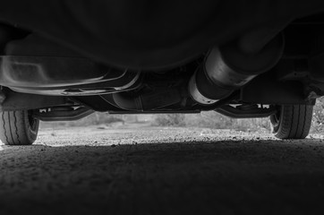 The bottom of a minibus standing on the road. Ground clearance. Close-up of transmission and...