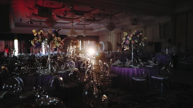 luxury wedding tables decoration with large candlesticks and flower bouquets in darkness slow motion