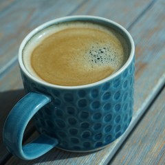 side view on ceramic cup of coffee on wooden table